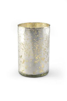 a gold and silver candle holder on a white background with the light reflecting off of it's surface