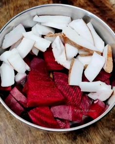 a metal bowl filled with cut up vegetables