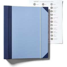 a blue binder next to a white sheet of paper