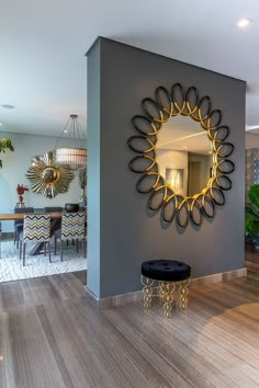 a living room with a mirror on the wall next to a wooden floor and table