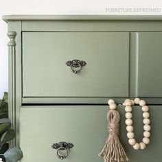 a green dresser with wooden beads on it