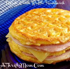 a close up of a plate of food with ham and waffle sandwich on it