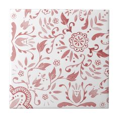 a pink and white tile with floral designs on it