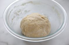 a ball of dough in a glass bowl