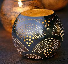 two black and gold vases sitting on top of a wooden table next to each other