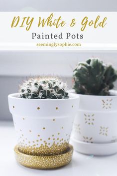 two white and gold painted pots sitting next to each other on top of a table