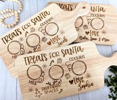 three wooden cutting boards with the words treats for santa written on them and other christmas decorations