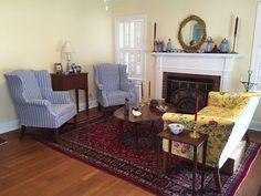 a living room filled with furniture and a fire place next to a fireplace on top of a hard wood floor