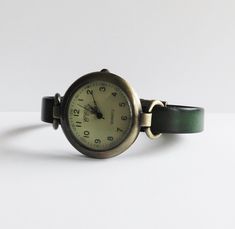 This is a women's watch with a green (made in Germany) leather flat cord strap. The style is retro minimalist with a simple distress look. The face of the watch is made in aged bronze finished alloy, free of nickel and lead, round shape 1.25 inches diameter. The strap comes in 6 sizes: XS for a 6.00 inches wrist S for a 6.25 inches wrist M for a 6.50 inches wrist L for a 6.75 inches wrist XL for a 7.00 inches wrist XXL for a 7.25 inches wrist If you need another size, please send me a message. T Classy Watch, Watch Women's, Retro Minimalist, Watches Women Leather, Minimalist Watch, Aged Bronze, Watch For Women, Simple Leather, Women's Watch