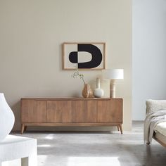 a living room with a couch, table and art hanging on the wall above it