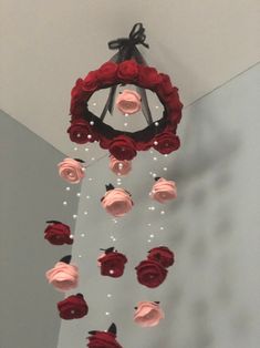 a pink and red rose mobile hanging from the ceiling