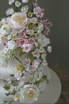 a wedding cake decorated with flowers and greenery