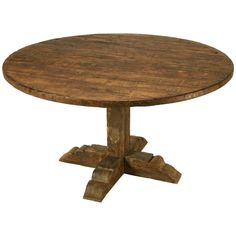 an old wooden table with four legs and a small round dining table on one end