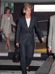 a woman in a suit walking down the street