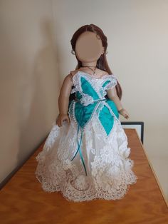 A magical, one of a kind ballgown for 18 inch dolls. This outfit comes in two pieces (Jewelry NOT Included): 1.) The Dress: A gorgeous off white satin dress with organza and lace overskirts and a bodice made of crushed green satin petals/leaves trimmed with lace and pearls. Features handmade 3D chiffon flowers along the lower edge of the skirt. Has hook-and-loop tape in the back for ease of closure. 2.) The Veil: An off-white organza veil trimmed with handmade 3D chiffon flowers and gothic lace. Secures to doll's hair via bobby pin (included). White Princess Dress Ball Gown For Fancy Dress, Princess Style Lace Pageant Dress, White Lace Princess Dress For Debutante Ball, White Princess Lace Pageant Dress, Lace Ball Gown For Pageant, White Princess Ball Gown For Fancy Dress, White Lace Princess Ball Gown, White Ruffled Ball Gown For Fancy Dress, Princess Gown With Lace Trim For Pageant