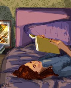 a woman laying in bed reading a book