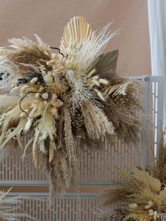 dried flowers are displayed in front of a wall