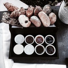 an assortment of doughnuts and condiments on a tray next to yarn