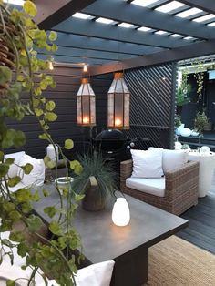 an outdoor living area with couches, tables and lights