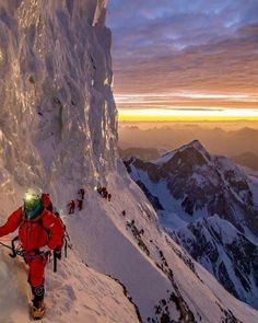 a man climbing up the side of a snow covered mountain