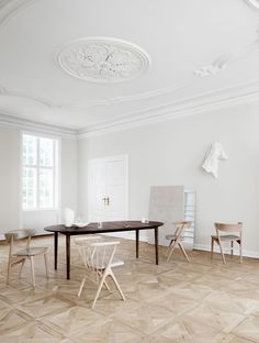 an empty room with chairs and a table in the middle is seen here, while another chair sits on the floor next to it