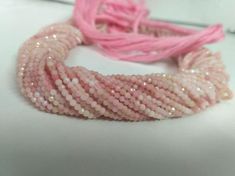 a pink and white beaded bracelet sitting on top of a table