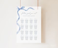 a blue and white wedding seating chart hanging on a wall with twine strings attached to it