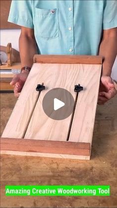 a person is holding a wooden board with two black clips on it and the words amazing creative woodworking tool in front of them