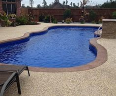 an empty swimming pool with lounge chairs around it