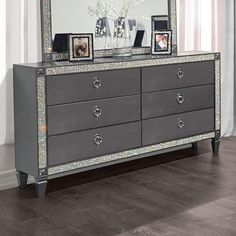 a silver dresser sitting in front of a mirror on top of a hard wood floor