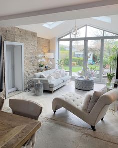 a living room filled with lots of furniture next to a large glass doored window