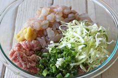 a bowl filled with meat and vegetables on top of a wooden table