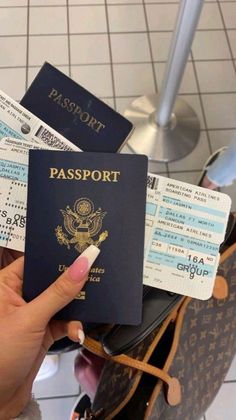 a person holding a passport in their hand and boarding tickets on the other side of them