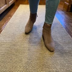 a woman standing on top of a rug in a kitchen