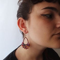 a close up of a person wearing some kind of earring with beads on it