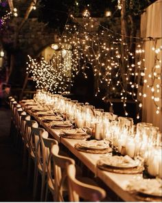 a long table is set with candles and place settings for an outdoor dinner or party