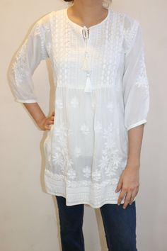 Discover the epitome of comfort and grace with our Soft Modal Cotton Elara Top.  Adorned with delicate lace inserts and exquisite Chikankari embroidery, this top seamlessly combines classic artistry with modern elegance. The softness of modal cotton embraces you in a gentle embrace, while the intricate Chikankari work adds a touch of timeless beauty.  Whether you're stepping out for a casual day or a chic evening affair, this top is the embodiment of effortless sophistication and style. Top Length - 30 inches. 3/4 sleeves Sizes -  S - Fits bust 34 M - fits bust 36 L - fits bust 38 XL - fits bust 40 0X - fits bust 42 1X - fits bust 44 Elegant Summer Top With Chikankari Embroidery, Elegant Summer Chikankari Embroidered Top, Elegant Chikankari Embroidered Top For Summer, Festive White Tops With Resham Embroidery, Festive White Top With Resham Embroidery, Elegant Festive Tunic With Chikankari Embroidery, Cotton Lace Top With Lace Work, Festive White Embroidered Top With Chikankari, Elegant Chikankari Embroidered Tunic For Festive Occasions