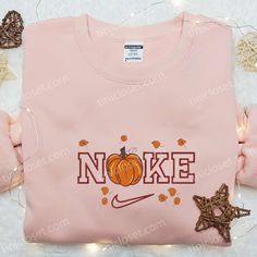 a pink shirt that says noke with pumpkins and starfish on it, surrounded by other items