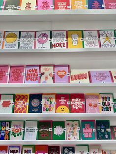 many greeting cards are displayed on shelves in a store, with the words love you so much