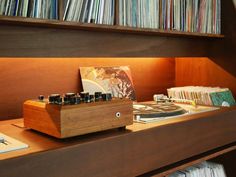 a record player sitting on top of a wooden shelf