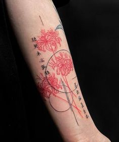 a woman's arm with red flowers and chinese writing on the left side of her arm