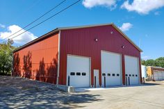 a red building with two garages on the front and one door open to let in light