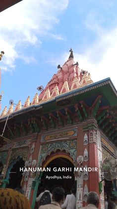 people standing in front of a colorful building with an ornate roof and dome on top