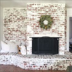 a brick fireplace with a wreath on the mantle