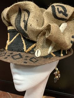 The Art of the Crown. This is a Spring and Summer Women's fedora hat. Great for tea parties and Kentucky Derby days. The fedora can turn around and have several different looks. This hat is accented with cowrie shells, trade beads, coconut button, burlap and lace . I is a wearable art selection. Don't delay order yours today. Zulu Hat, African Crown, African Hat, Short Brim Hat, Womens Fedora Hat, Ladies Dress Hats, Women Fedora, African Hats, Funky Hats