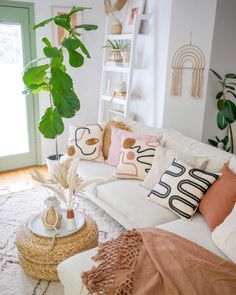 a living room filled with lots of furniture and plants