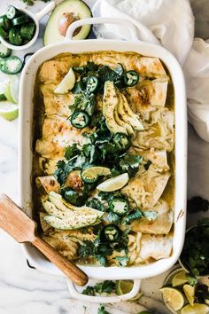 a casserole dish filled with chicken, spinach and artichokes