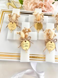 wedding place cards with gold foil and burlap ribbon tied around them on a white table cloth