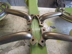 the metal parts are attached to the green piece of wood that is being worked on