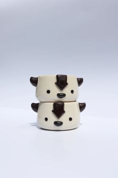 two ceramic bowls with brown and white cow heads on the top one has black spots